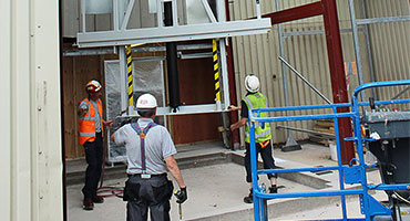 Muncitori instalând un ascensor